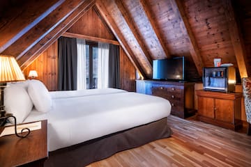 a bedroom with a wooden ceiling and a tv