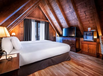 a bedroom with a wooden ceiling and a tv