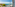 Sunny balcony overlooking turquoise sea and coastal marina with boats.