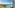 Sunny balcony overlooking turquoise sea and coastal marina with boats.