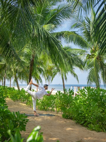a man doing yoga on a beach