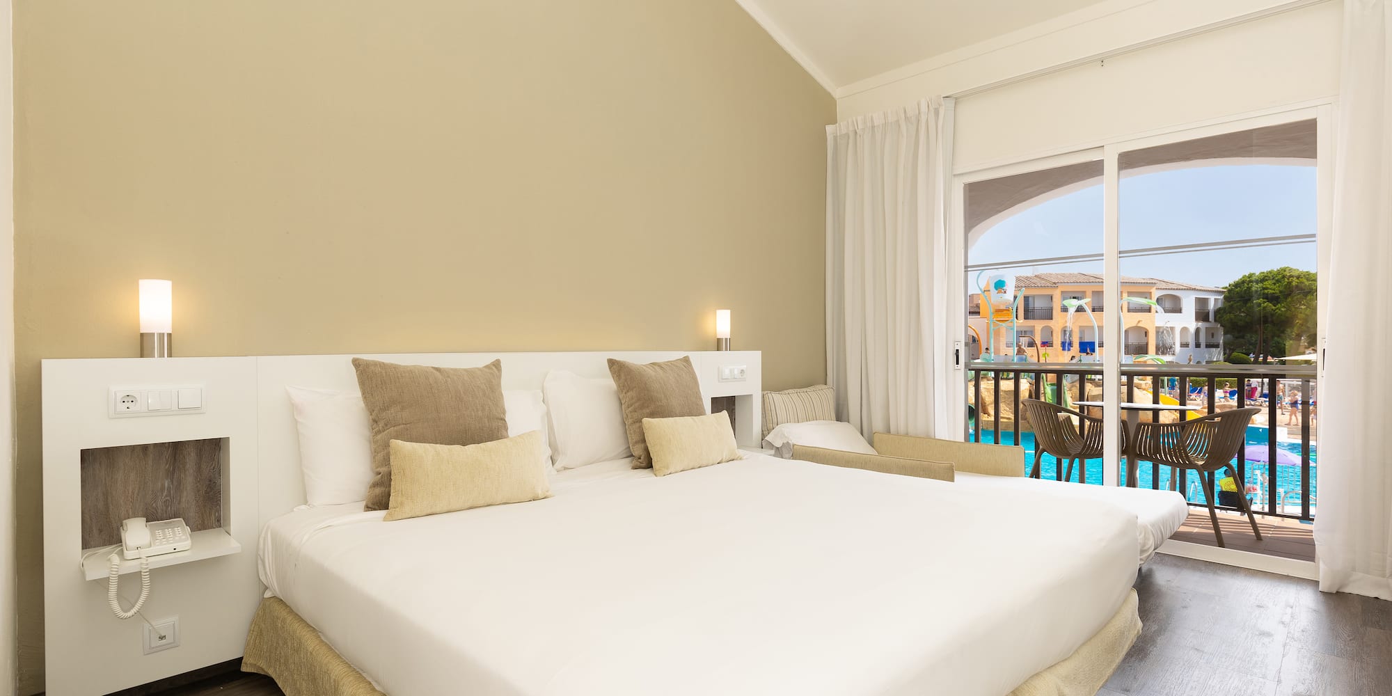 a bed in a room with a pool in the background