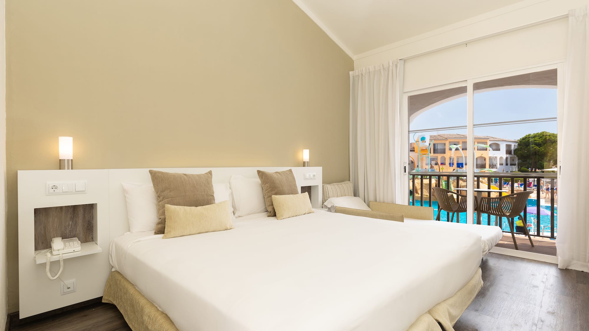 a bed in a room with a pool in the background