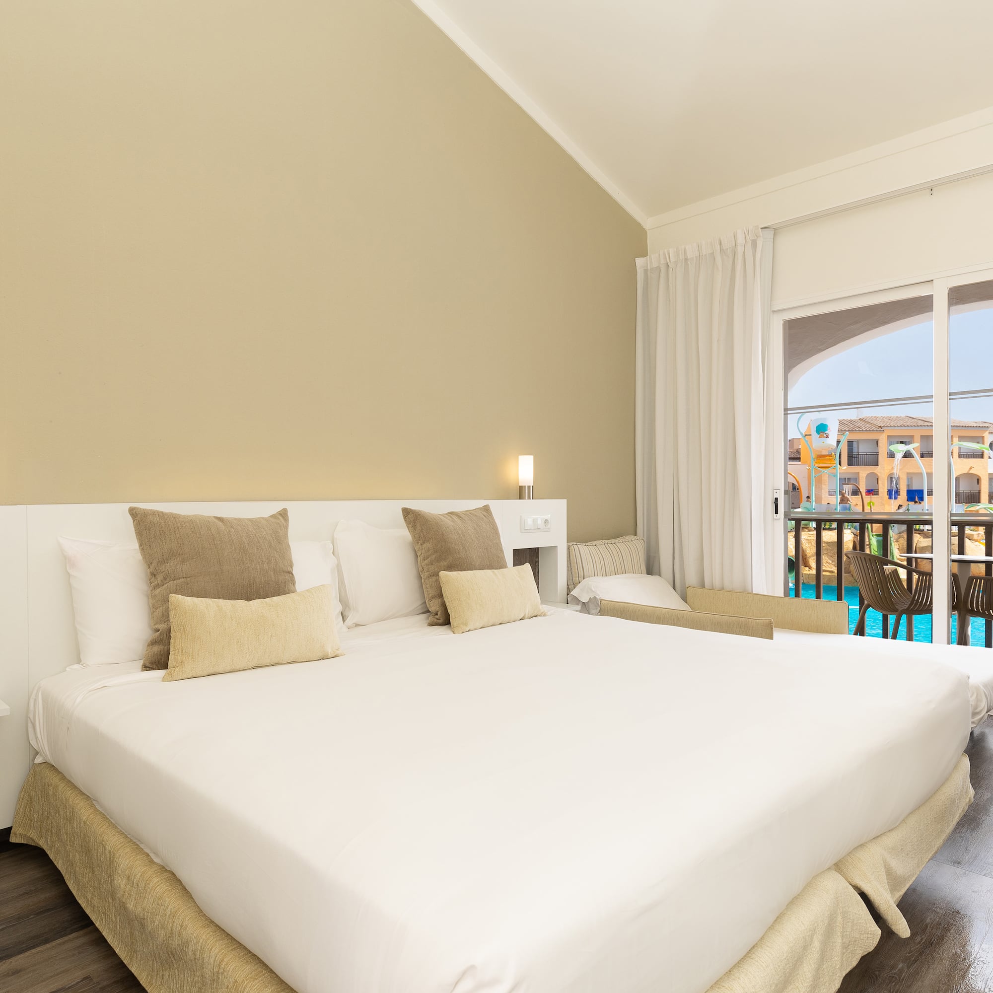 a bed in a room with a pool in the background