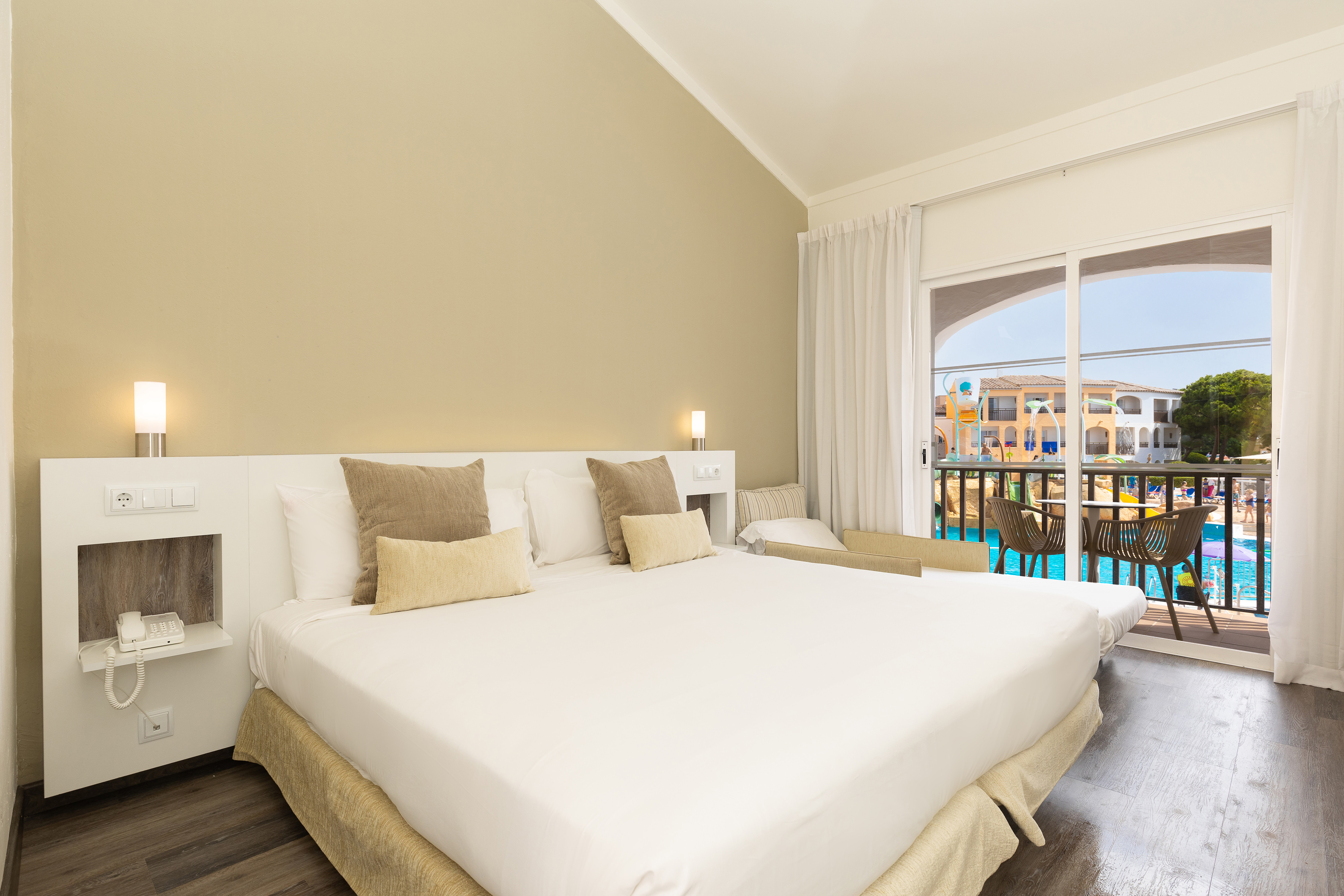 a bed in a room with a pool in the background