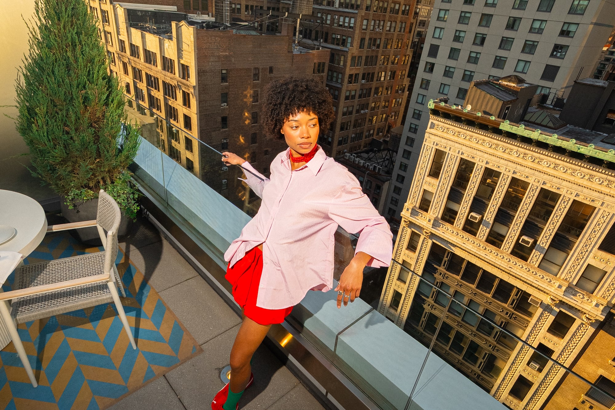 a woman standing on a balcony with a city in the background