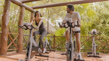 a man and woman on exercise bikes
