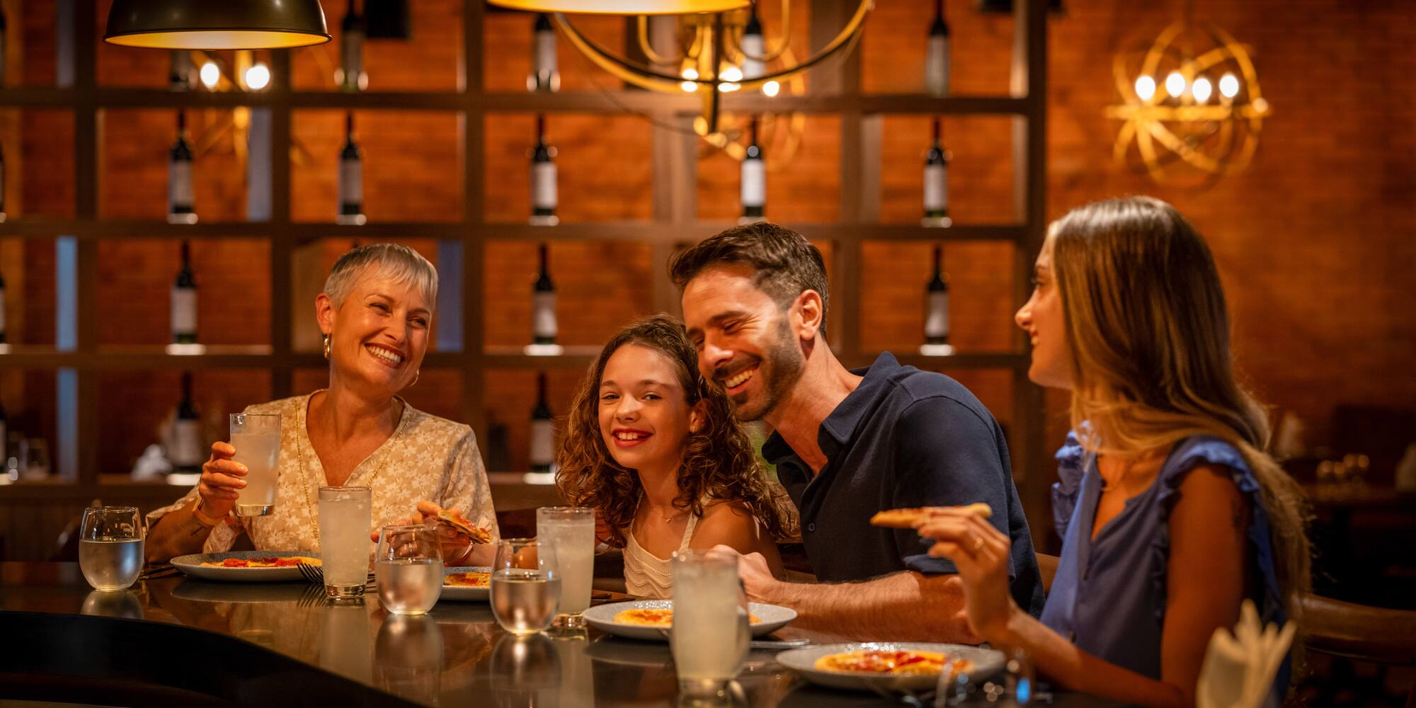 a group of people sitting at a table eating pizza