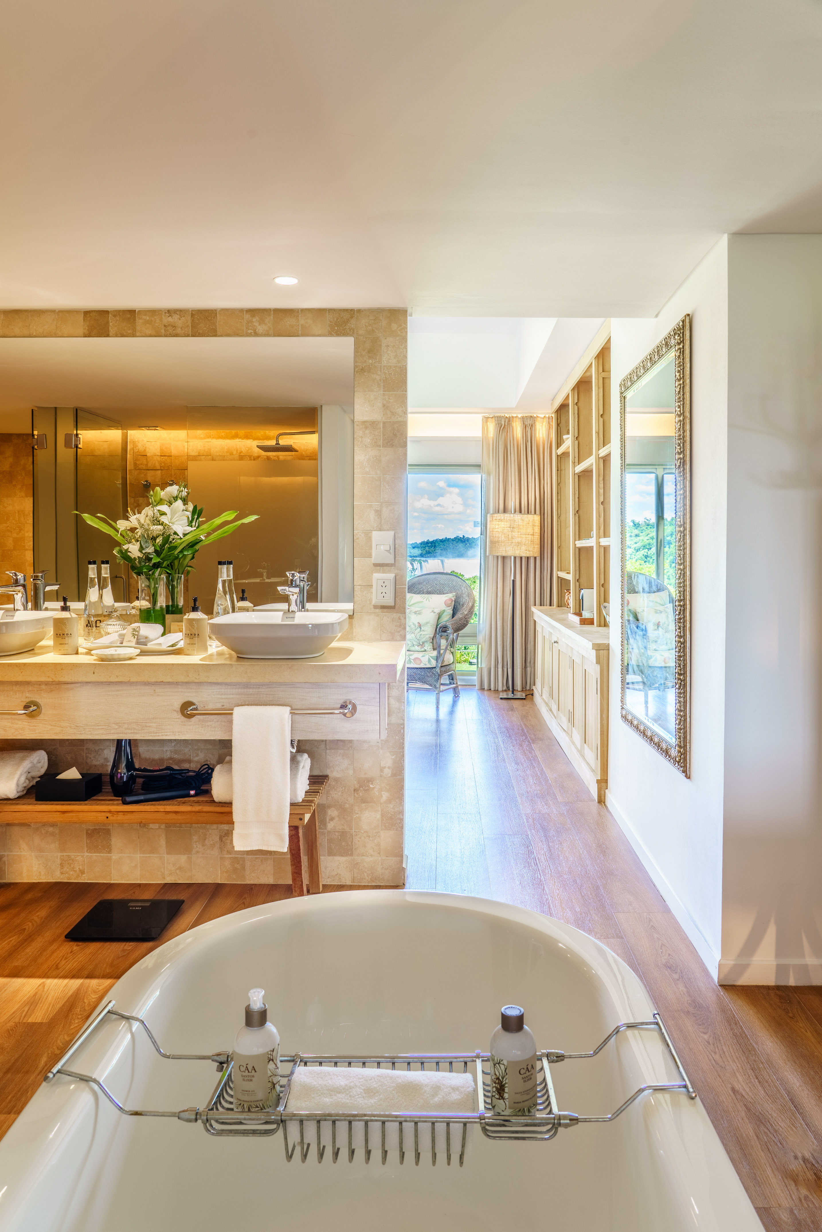 Luxury bathroom: freestanding tub, double vanity, and scenic window view.