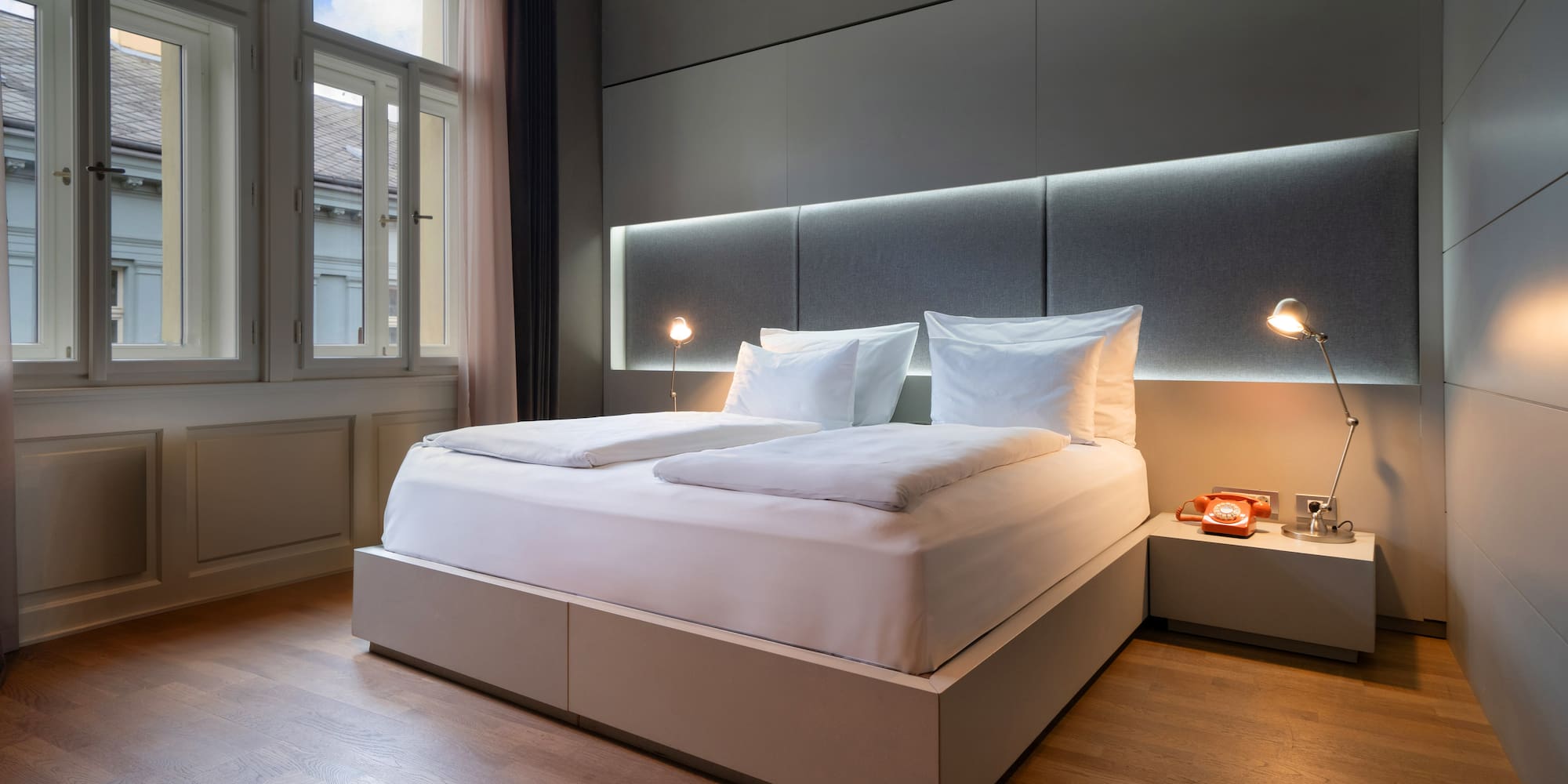 a bed with a headboard and lamps