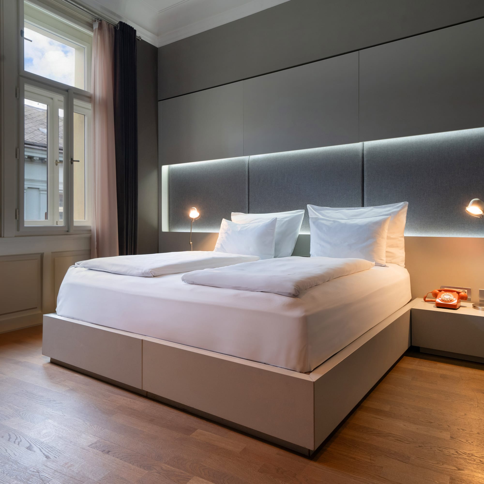 a bed with a headboard and lamps