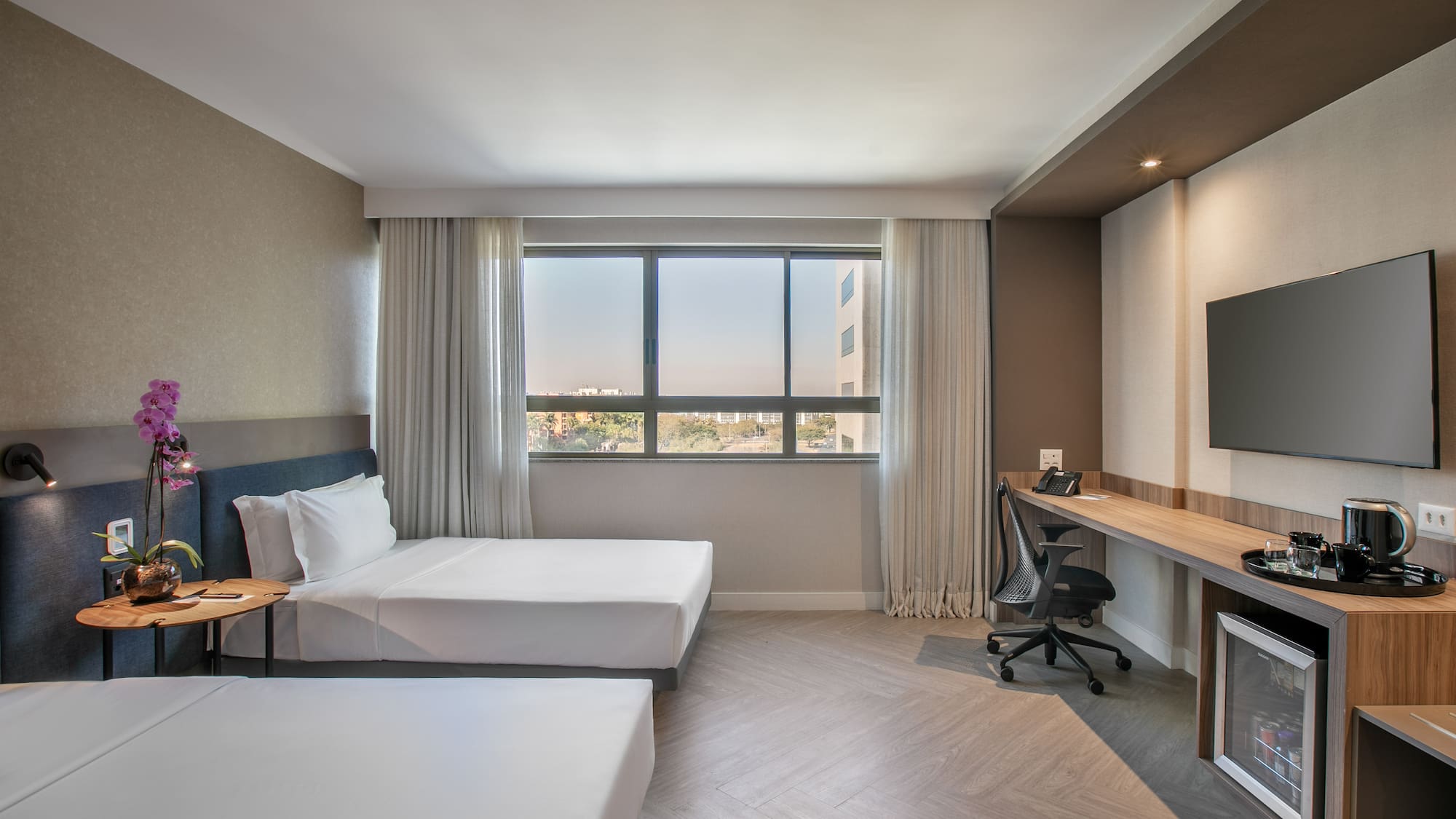 a room with two beds and a desk