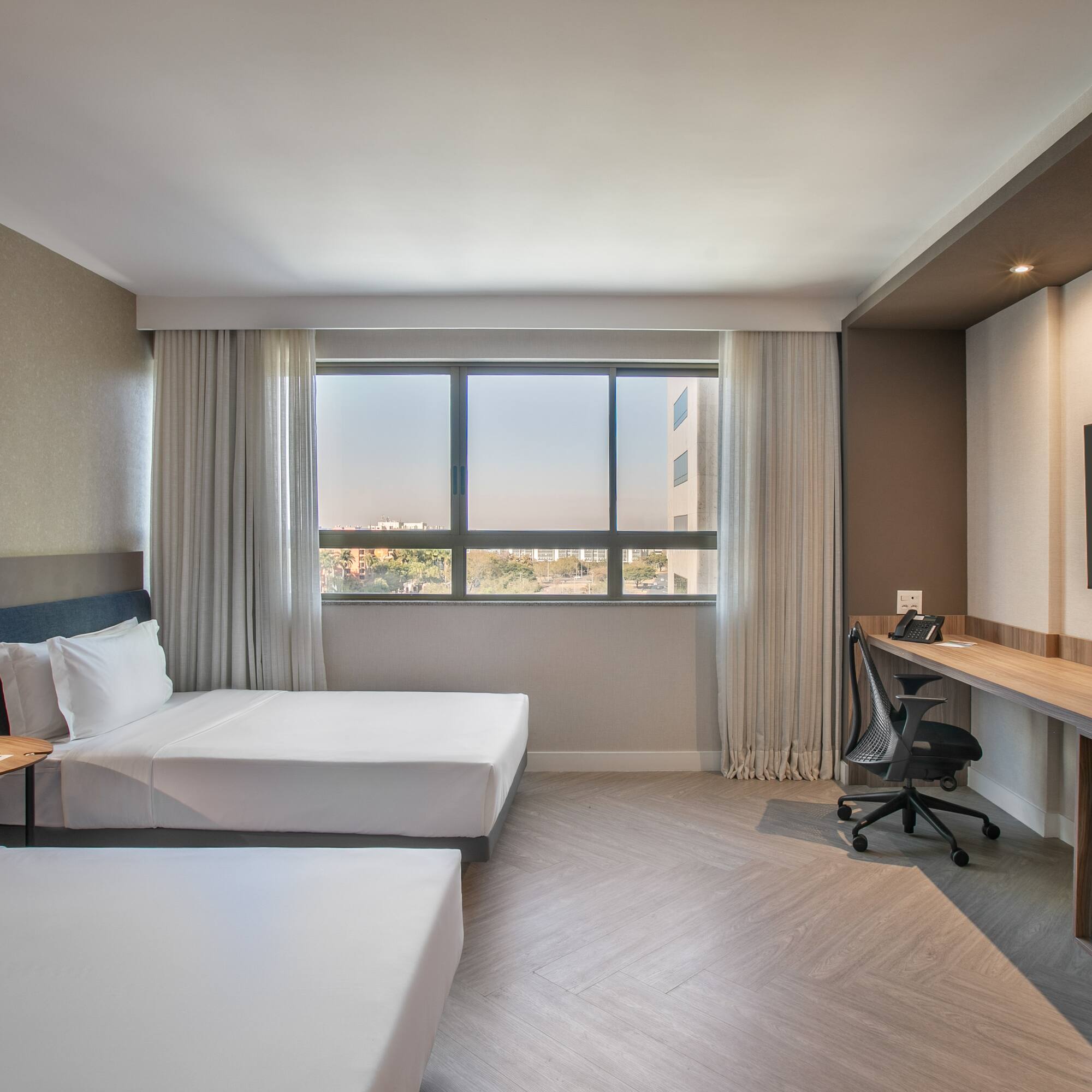 a room with two beds and a desk