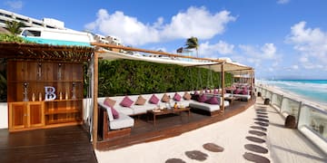 a patio area with a table and chairs on a beach
