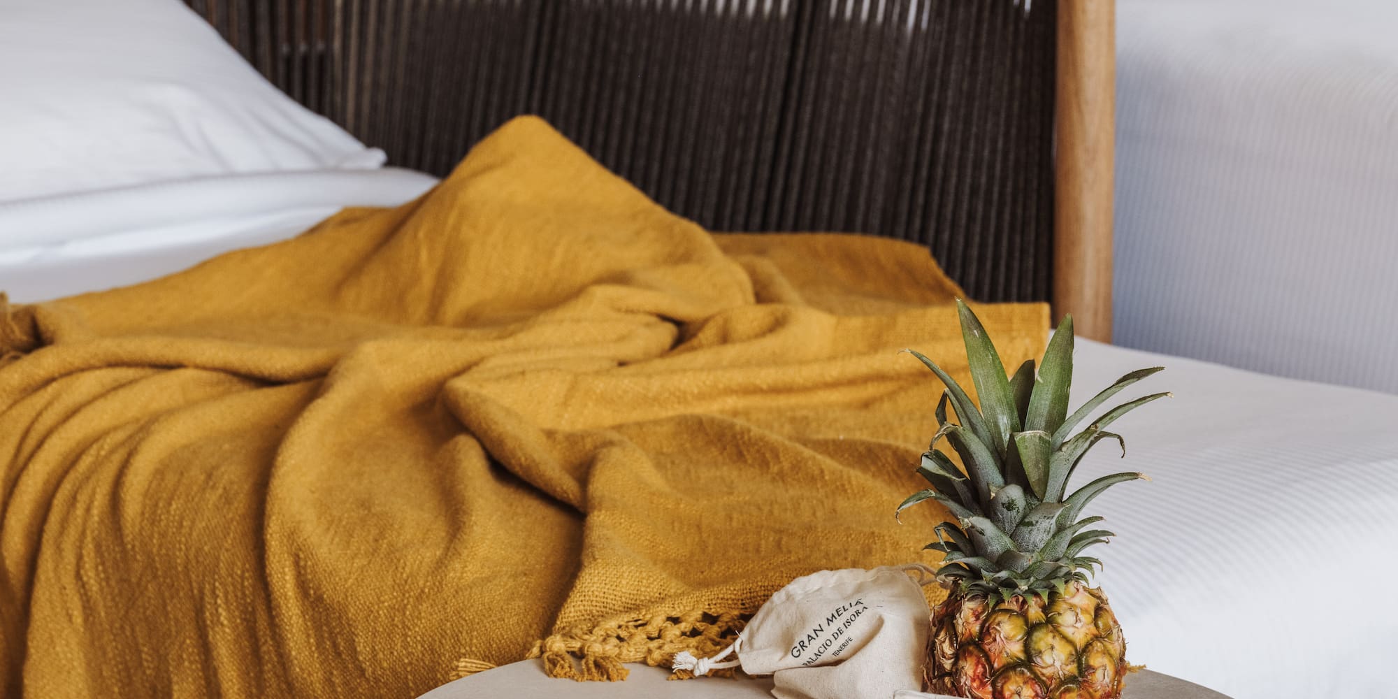 a pineapple on a table next to a bed