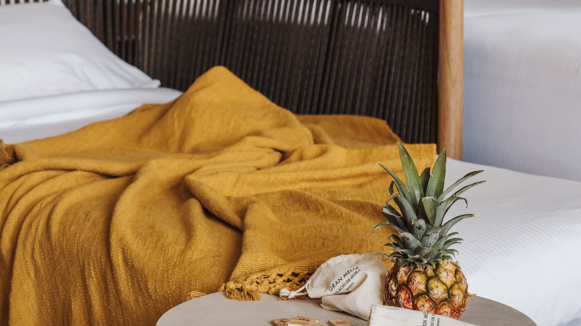 a pineapple on a table next to a bed