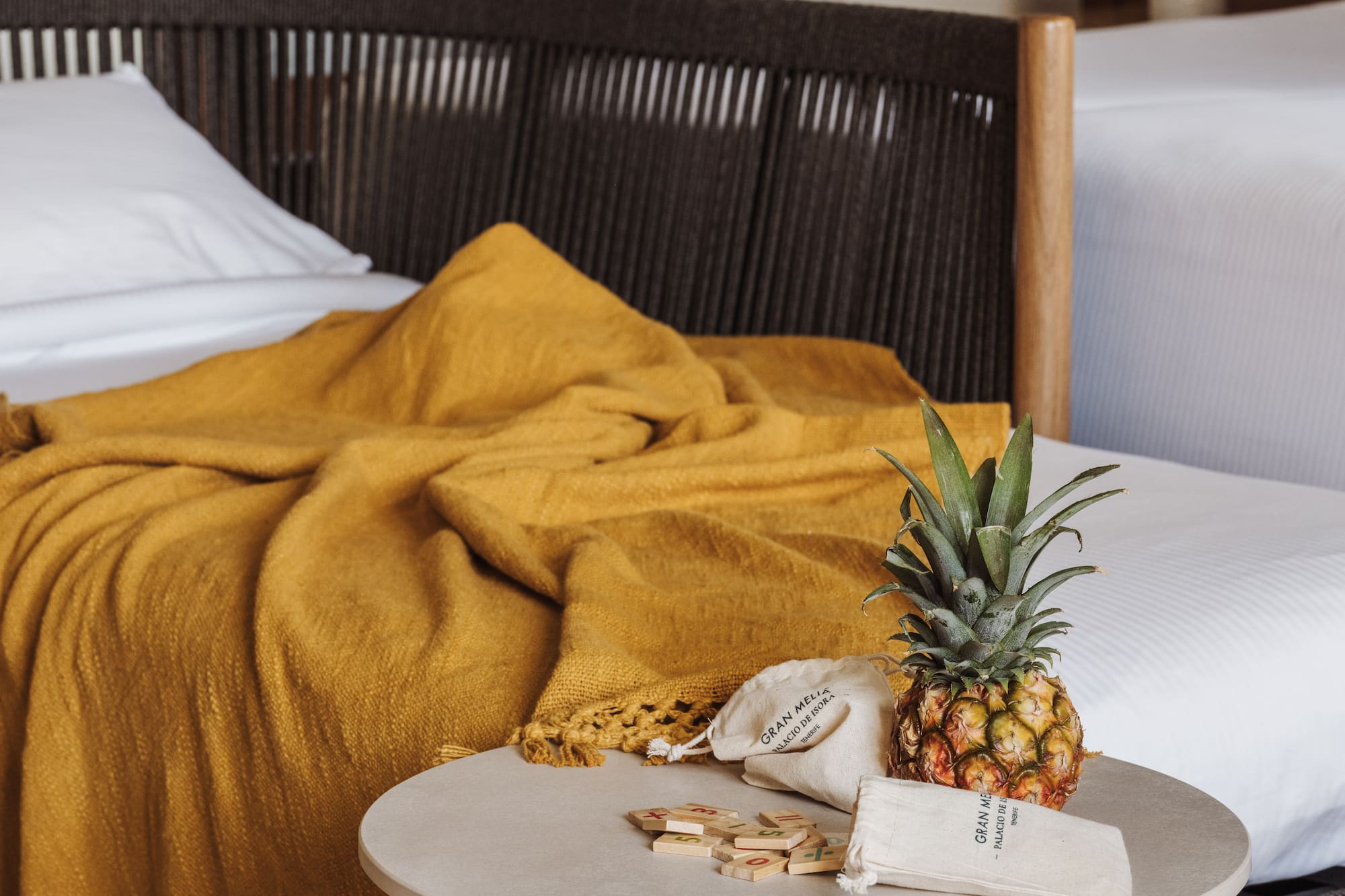 a pineapple on a table next to a bed