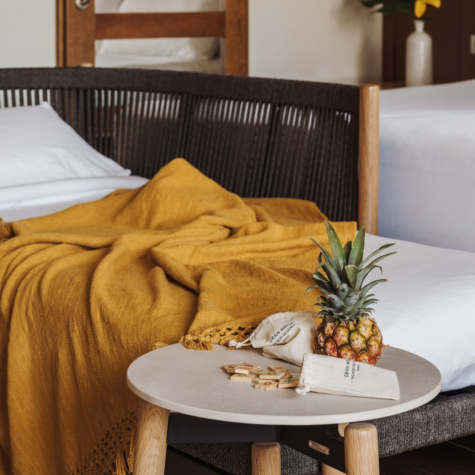 a pineapple on a table next to a bed