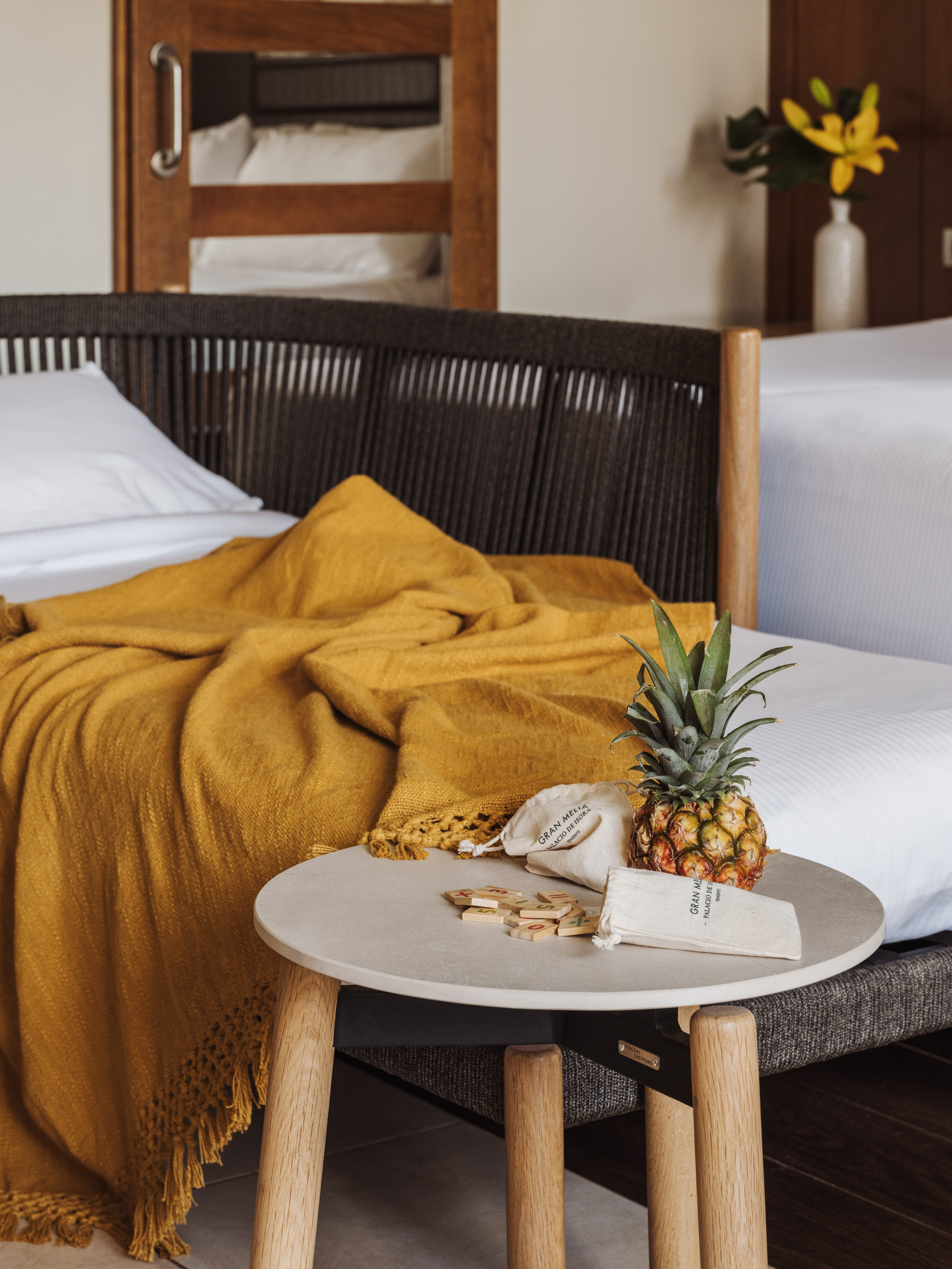 a pineapple on a table next to a bed