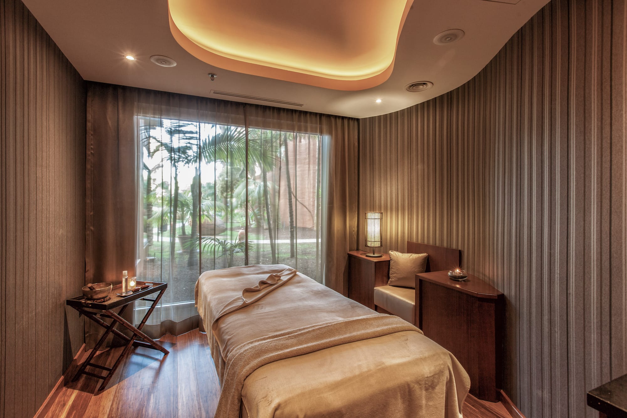 a massage room with a bed and a window