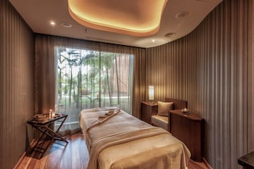 a massage room with a bed and a window