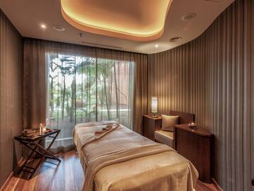 a massage room with a bed and a window