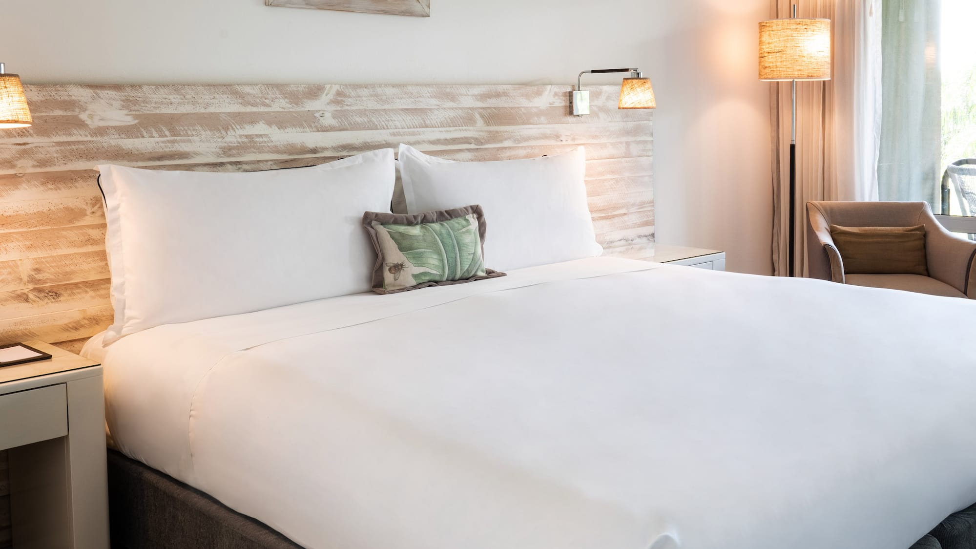 a bed with a white sheet and a wood headboard