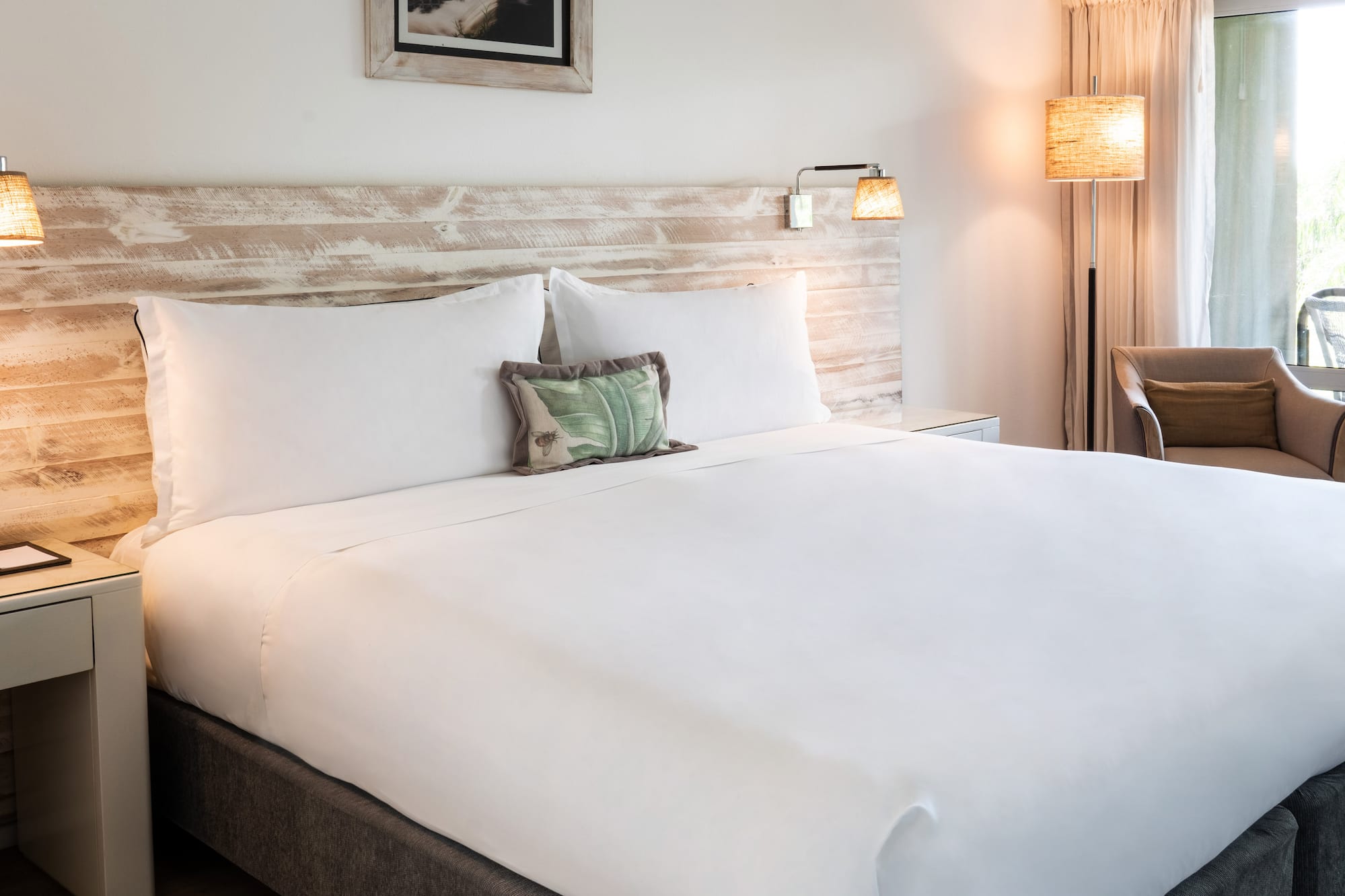 a bed with a white sheet and a wood headboard