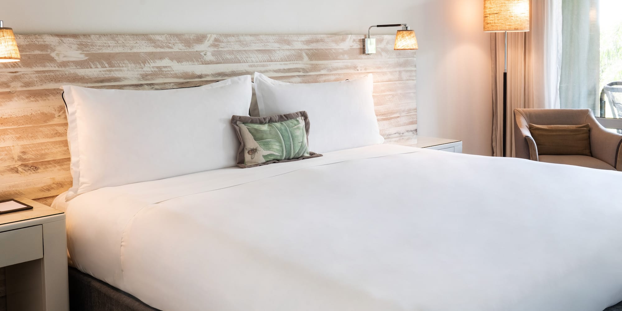 a bed with a white sheet and a wood headboard