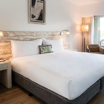 a bed with a white sheet and a wood headboard