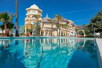 a pool with palm trees and buildings in the background