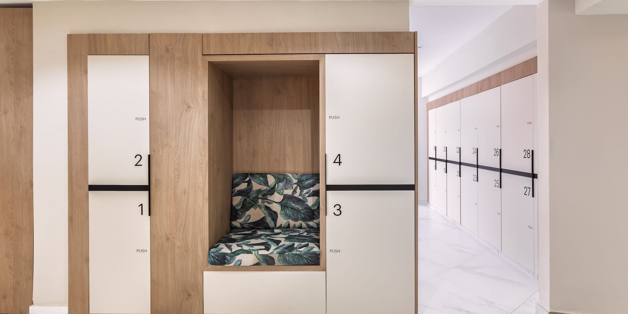 Modern wood lockers, white numbered doors, and integrated bench in a changing room.
