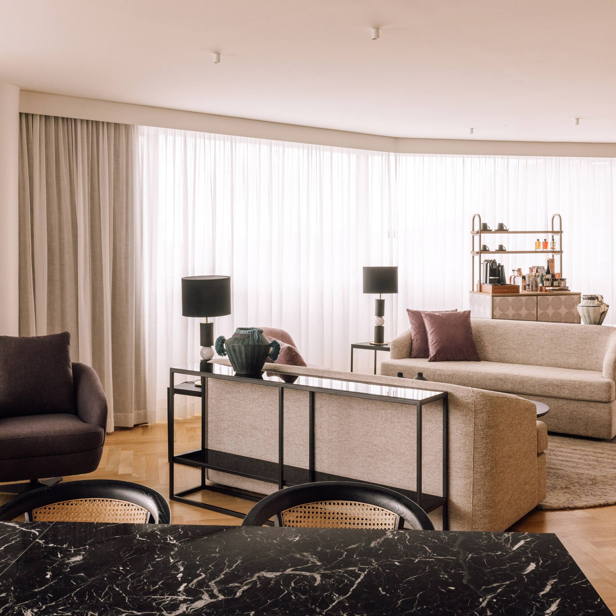 a living room with a black marble table and couches