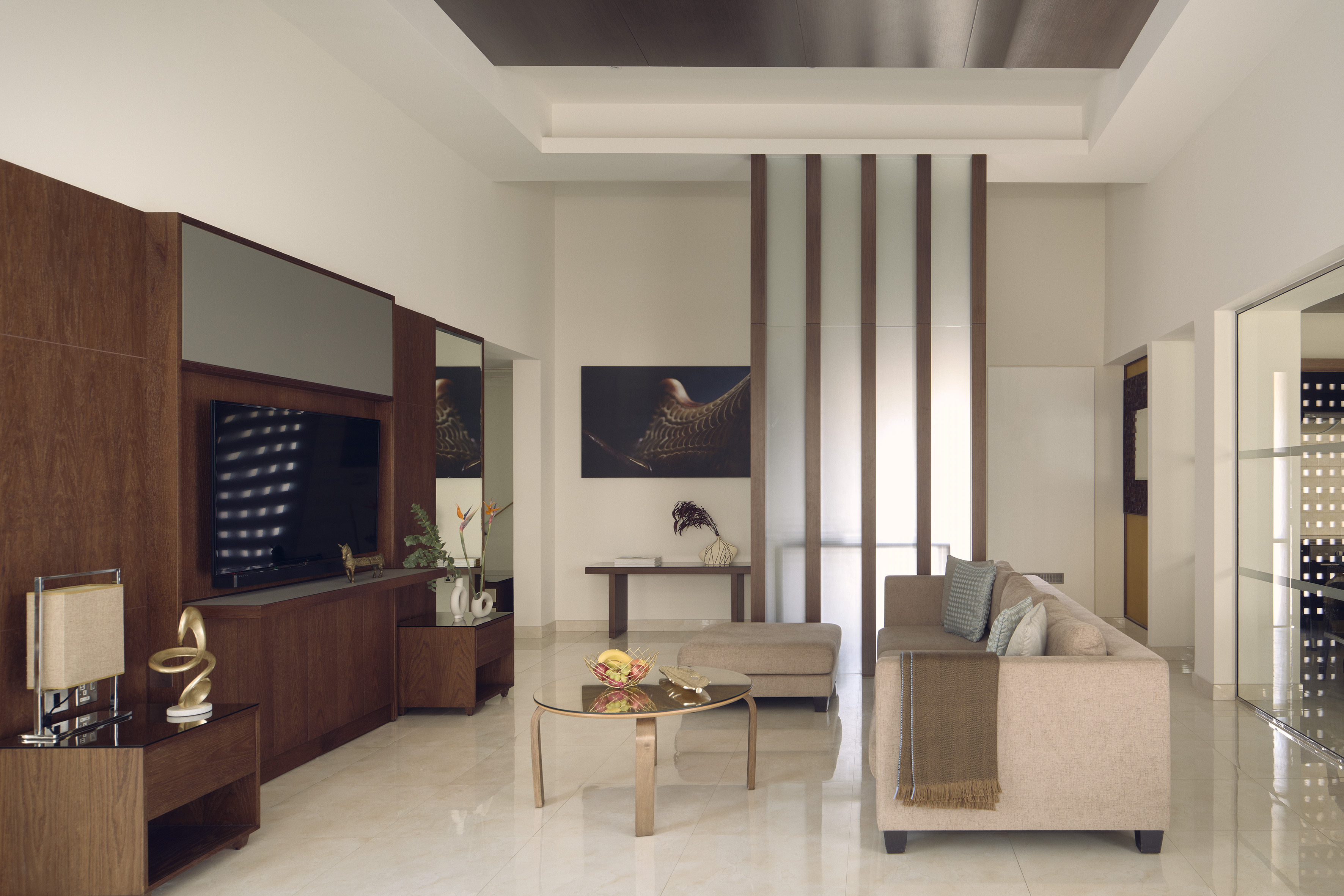 Modern living room interior with wooden TV unit, sofa, and coffee table.