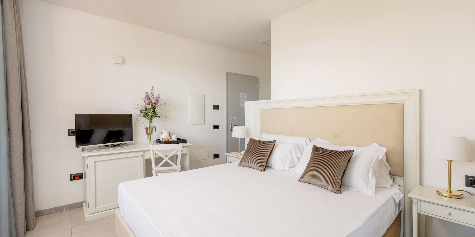 a bed with pillows and a tv in a room