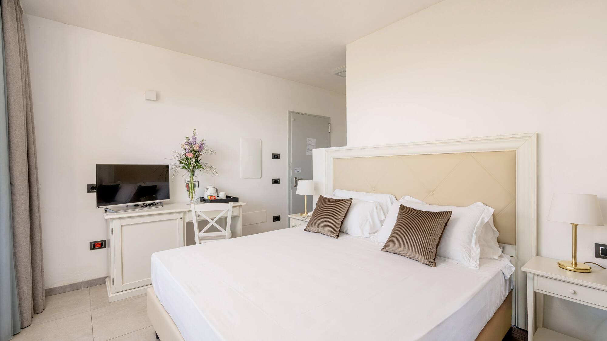 a bed with pillows and a tv in a room
