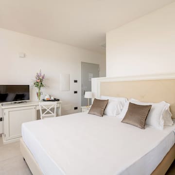 a bed with pillows and a tv in a room