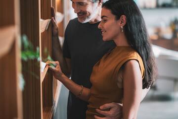 a man and woman looking at a shelf