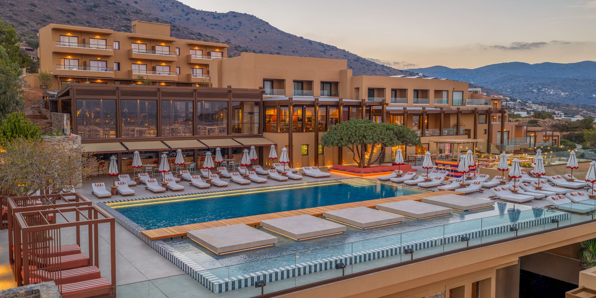 a swimming pool and a building with a mountain in the background