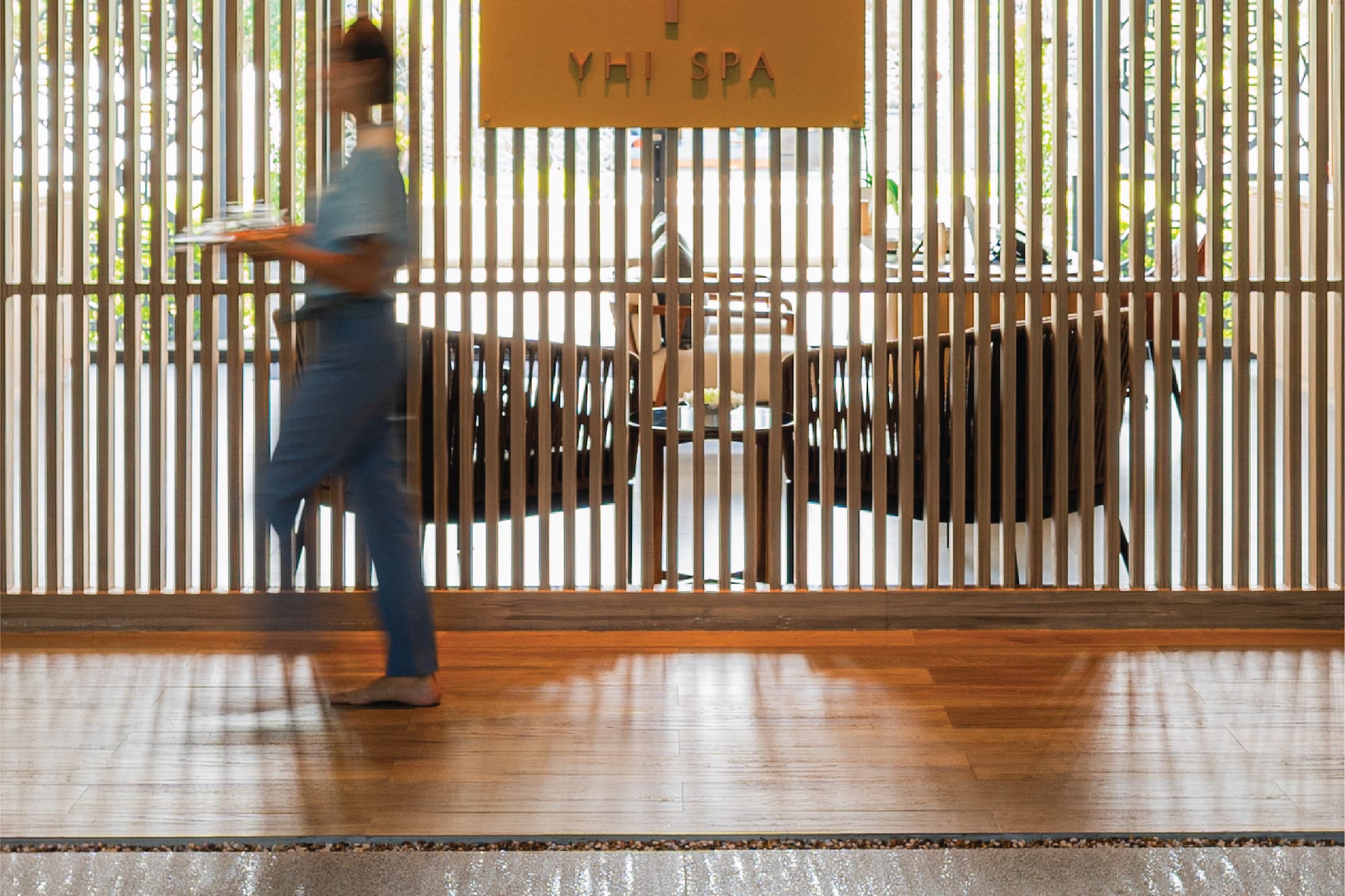 a woman walking in front of a wooden wall