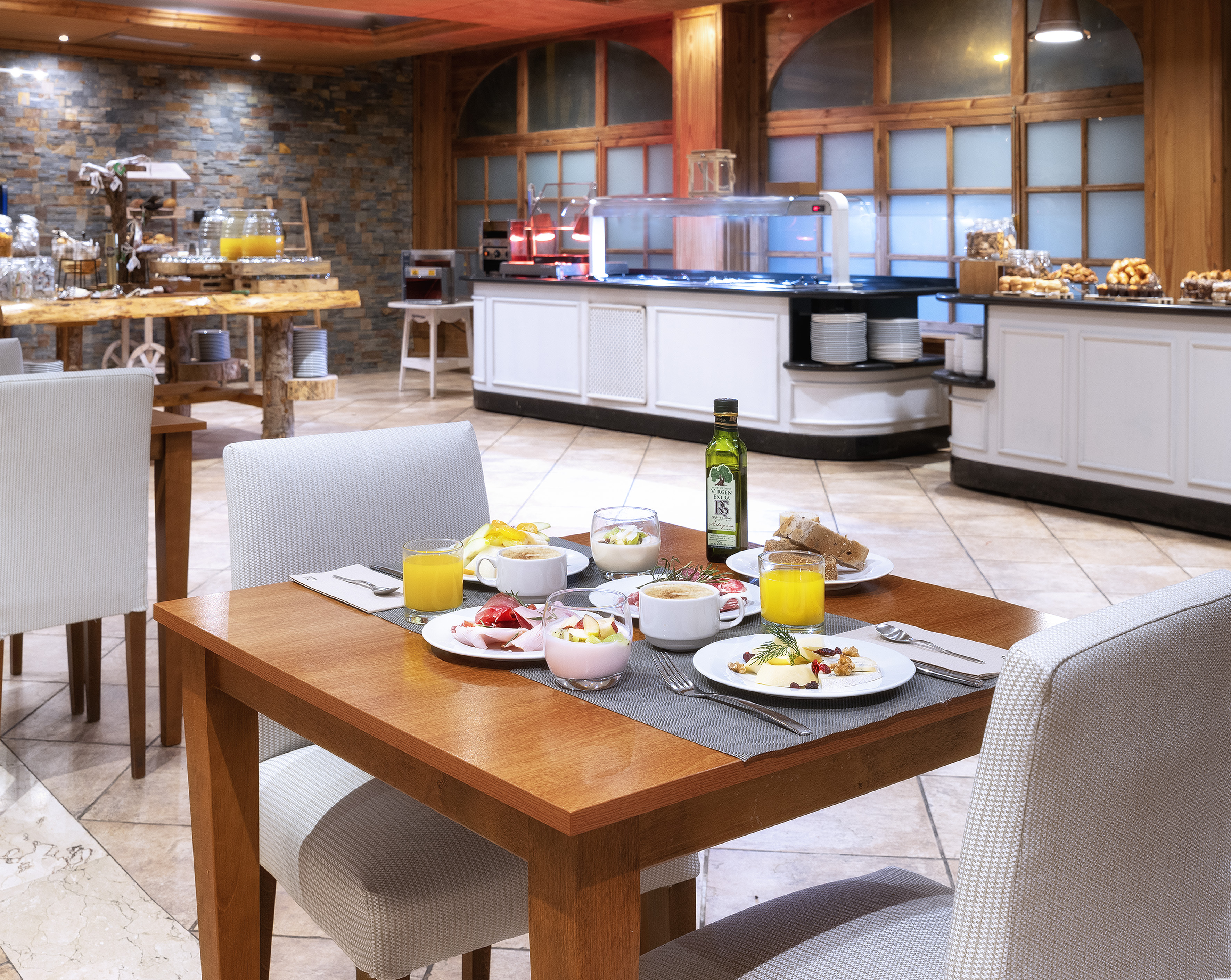 Breakfast table with juice, coffee, yogurt, and cheese; hotel buffet background.