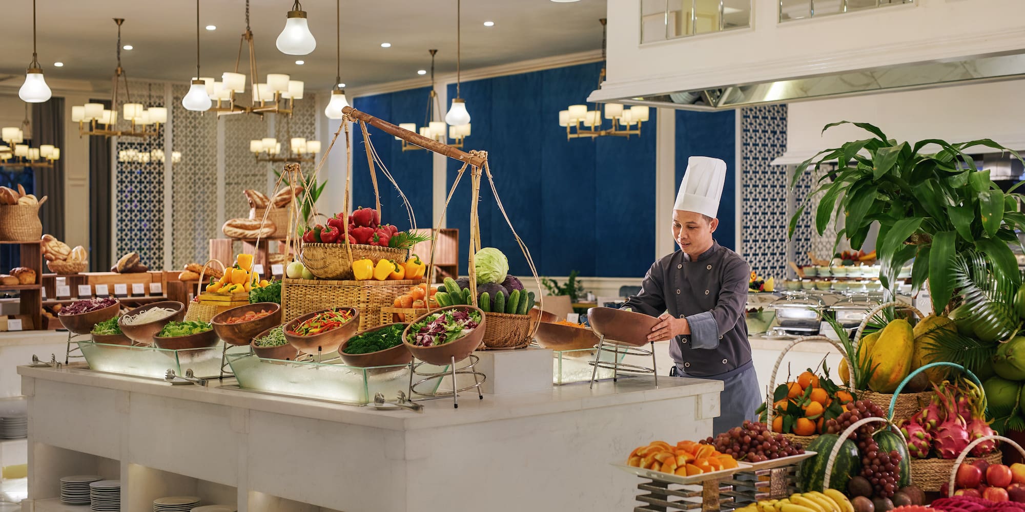 a chef standing behind a counter with fruits