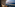 Oceanfront balcony with rocking chair, wicker table, sunset ocean view.