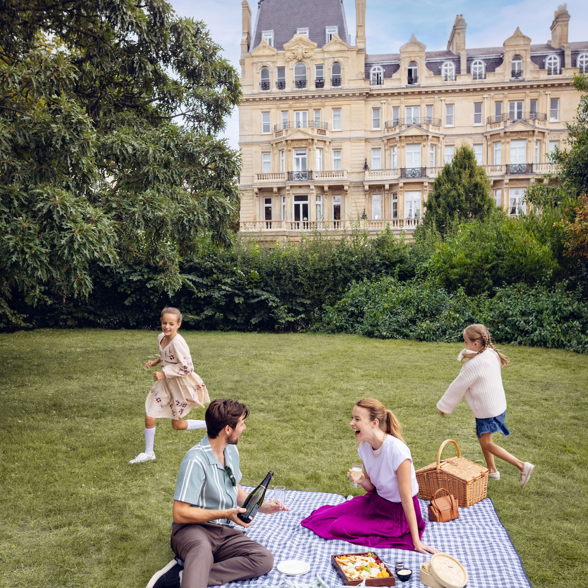 A group of people gathered on a picnic blanket in a park.