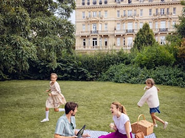 a group of people on a picnic blanket in a park