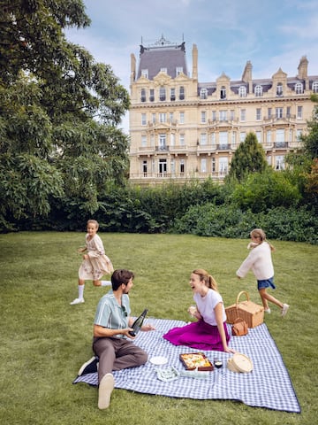 a group of people on a picnic blanket in a park