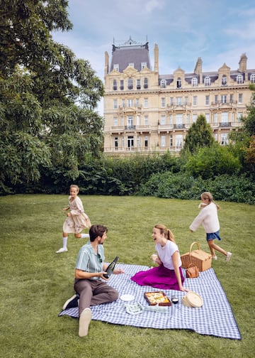 a group of people on a picnic blanket in a park