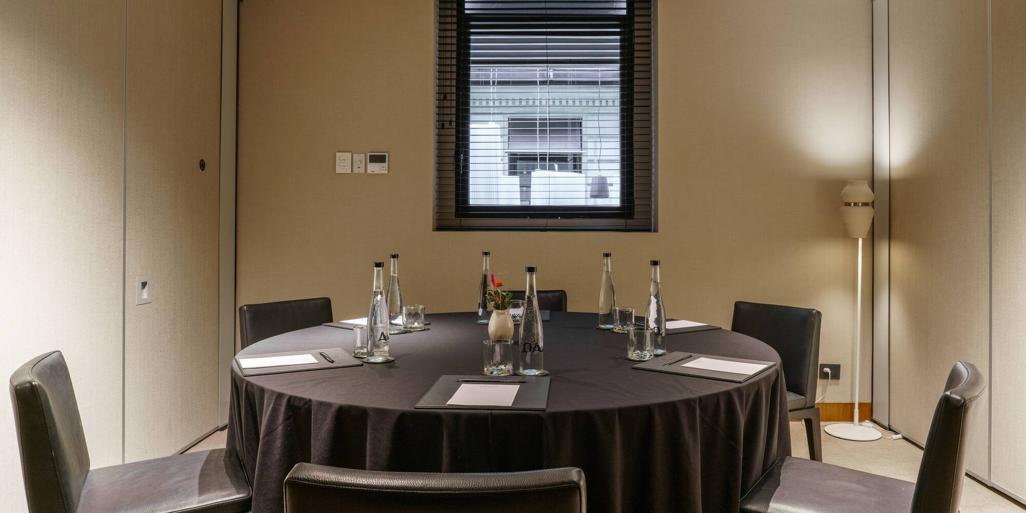 a round table with black tablecloth and chairs in a room