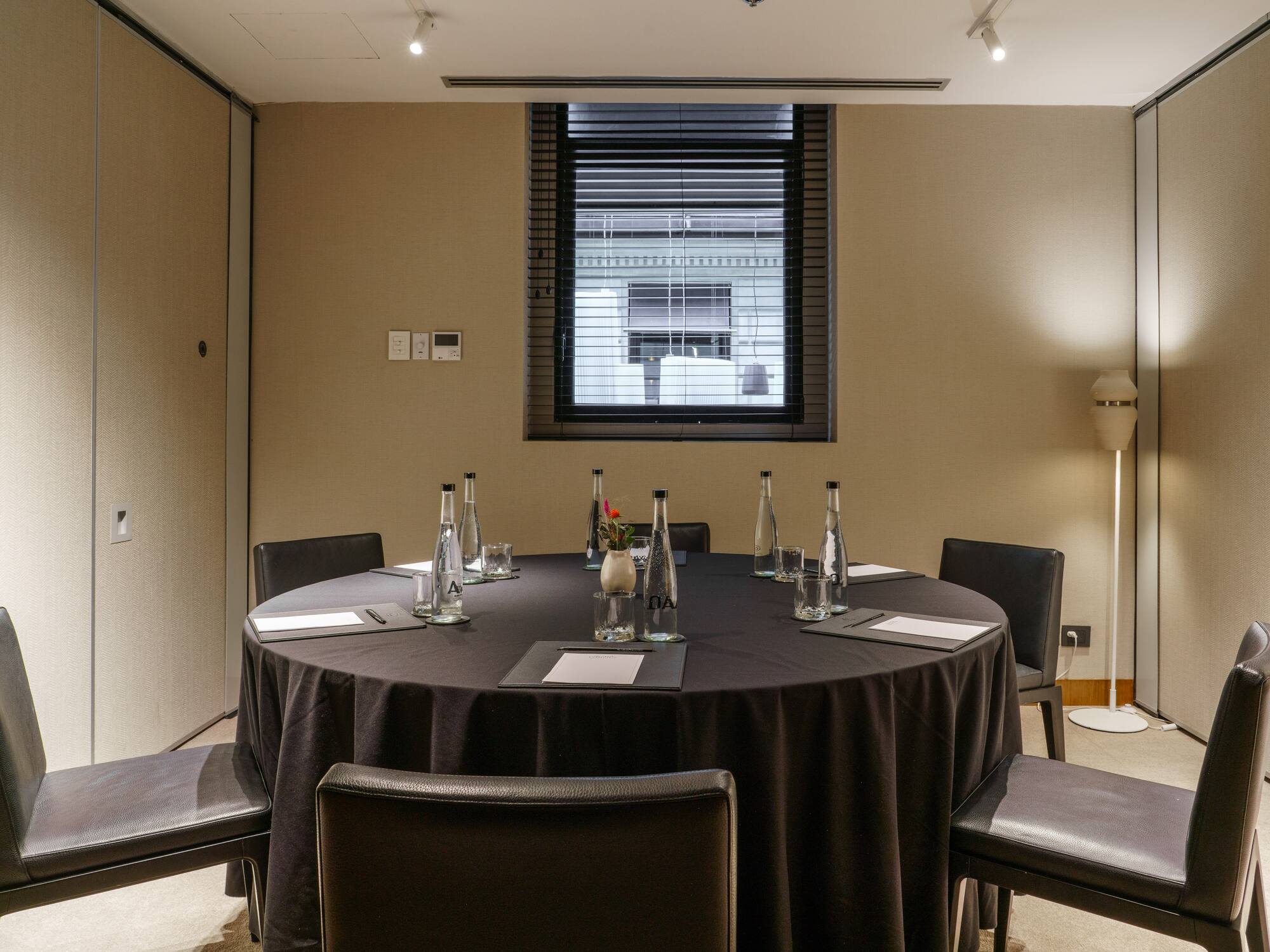 a round table with black tablecloth and chairs in a room