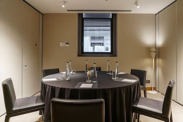 a round table with black tablecloth and chairs in a room